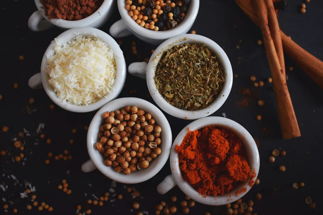 a photo with small dishes showing a variety of Indian spices